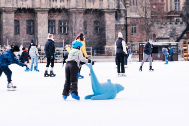 04.01.2022 Budapeşte. Mutlu küçük oğlan ve kız kışın paten kaymayı öğreniyor. Hobiler ve boş zaman. Kış sporları. Aile kışı sporu..