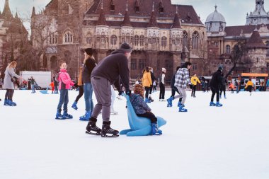04.01.2022 Budapeşte. Mutlu küçük oğlan ve kız kışın paten kaymayı öğreniyor. Hobiler ve boş zaman. Kış sporları. Aile kışı sporu..