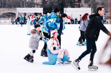04.01.2022.Budapest.Winter sports.Family winter sport.Holiday and seasonal concept.Activity,Adult,Child,Childhood, Daughter.Happy little boy and girl learning to skate in winter.Hobbies and Leisure.