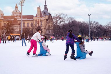 04.01.2022.Budapest.Happy little boy and girl learning to skate in winter.Hobbies and Leisure.Winter sports.Family winter sport.Holiday and seasonal concept.Activity,Adult,Child,Childhood, Daughter.