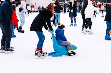 04.01.2022.Budapest.Winter sports.Family winter sport.Holiday and seasonal concept.Activity,Adult,Child,Childhood, Daughter.Happy little boy and girl learning to skate in winter.Hobbies and Leisure.