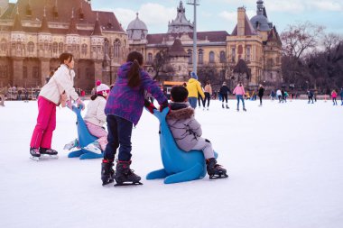 04.01.2022.Budapest.Family winter sport.Holiday and seasonal concept.Happy little boy and girl learning to skate in winter.Hobbies and Leisure.Winter sports.Activity,Adult,Child,Childhood, Daughter.