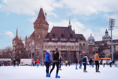 04.01.2022 Budapeşte. Aile kış sporu. Yumuşak, seçici odaklanma. Açık havada. Çocuklar ve yetişkinler kış günü buz pateni pistinde buz pateni yapmaya giderler..