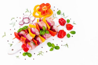 Chicken Skewers meat.Raw chicken leg meat skewers with vegetables,peppers, onions,white background.Uncooked mixed meat skewer with peppers.Skewers with pieces of raw meat, red, yellow pepper.Top view.