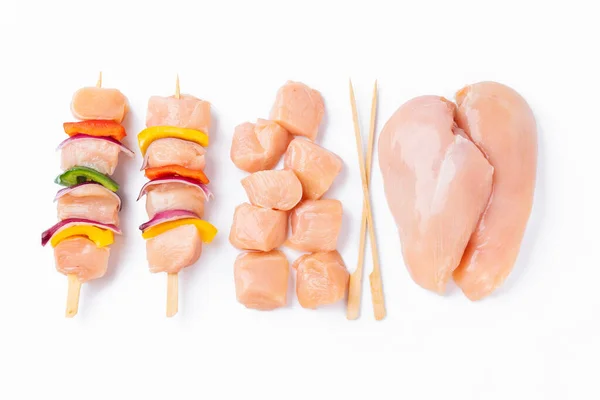 Chicken Skewers breast fillet meat.Uncooked meat skewer with peppers.Skewers with pieces of raw meat,red,yellow pepper.Top view.Raw chicken skewers with vegetables, peppers,onions,white background.