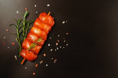 Tavuk şişleri. Taze marine edilmiş derisiz tavuk bacağı. Siyah otlu et şişleri. Tasarımcılar için tedarik..