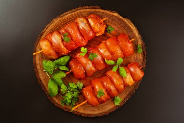 Tavuk şişleri. Taze marine edilmiş derisiz tavuk bacağı. Siyah otlu et şişleri. Tasarımcılar için tedarik..