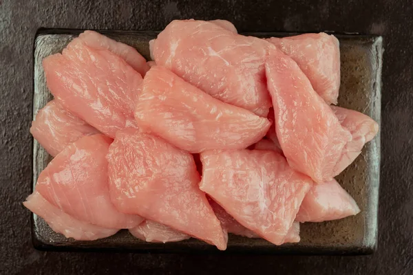 鶏の切り身 七面鳥肉の新鮮な作品 生の鶏 黒の背景にセラミックボード上の七面鳥肉の生の作品 クローズアップ — ストック写真