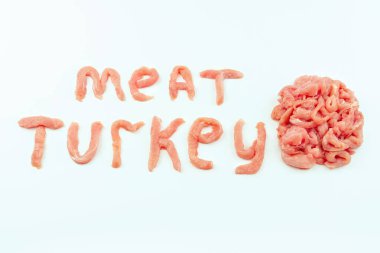 Beyaz bir arka planda çiğ etle yazılmış et kelimesi. Taze hindi eti. Çiğ tavuk eti..