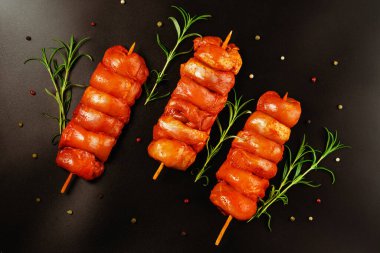 Taze terbiye edilmiş derisiz tavuk budu. Siyah bir arka planda taze otlarla birlikte et şişleri. Süper manzara. Terbiye edilmiş taze taze taze et..