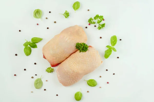 Chicken leg meat.Raw fresh chicken leg meat with skin and with fresh herbs on a white background.Copy space.Copy space.Food for retail.Procurement for designers.Ogranic food,healthy eating.Food