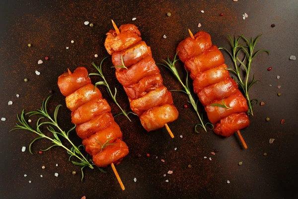 Taze terbiye edilmiş derisiz tavuk budu. Siyah bir arka planda taze otlarla birlikte et şişleri. Süper manzara. Terbiye edilmiş taze taze taze et..