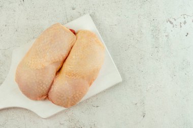 Gıda konsepti. Güzel manzara. Tavuk budu eti. Arka planda derisi olan çiğ tavuk budu eti. Perakende için yiyecek..