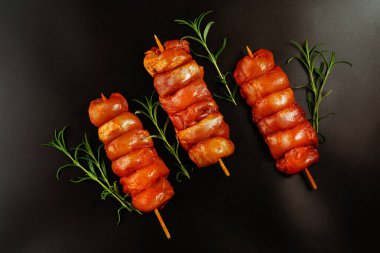 Tavuk şişleri. Taze marine edilmiş derisiz tavuk bacağı. Siyah otlu et şişleri. Tasarımcılar için tedarik..