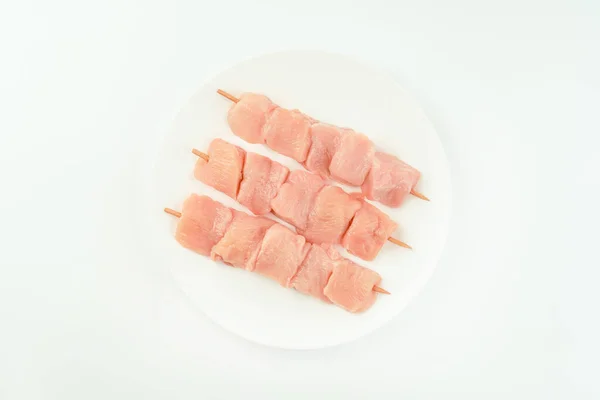 白い背景にスーパーマーケットのための白いプレート上に生の鶏の肉フィレから串 小売のための食品 Topビュー 生の鶏の胸フィレ — ストック写真