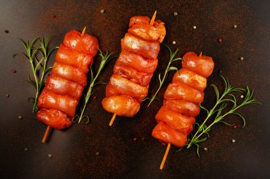 Taze terbiye edilmiş derisiz tavuk budu. Siyah bir arka planda taze otlarla birlikte et şişleri. Süper manzara. Terbiye edilmiş taze taze taze et..