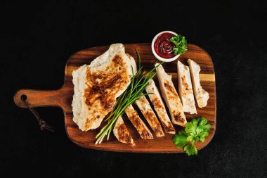 Evde hızlı yemek. Fast food. Fast food.Tavuk filetoları yarı pişene kadar kızarır, meyve yapar. Yarı pişmiş tavuk filetoları, hafif kızarmış, taze bitkilerle birlikte koyu bir arka planda..