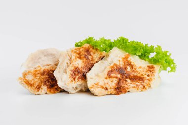 Tavuklu fileto, yarı pişmiş, yarı pişmiş ve beyaz arka planda taze bitkilerle birlikte. Fast food. Fast food. Fast food. Evde çabuk pişiyor. Boşluğu kopyala.