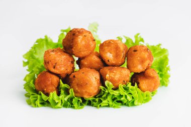 Kızarmış tavuk nuggetları. Beyaz arka planda yeşil marul yapraklı kızarmış tavuk filetosu. Tavuk rostosu, et, fileto. Ev yapımı hızlı yemek. Tavuklu şnitzel. Hızlı pişiyor.