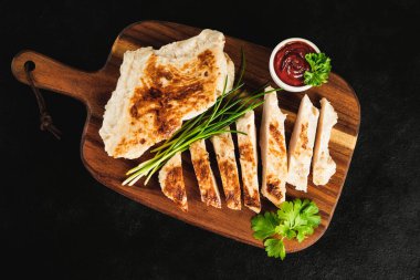 Evde hızlı yemek. Fast food. Fast food.Tavuk filetoları yarı pişene kadar kızarır, meyve yapar. Yarı pişmiş tavuk filetoları, hafif kızarmış, taze bitkilerle birlikte koyu bir arka planda..