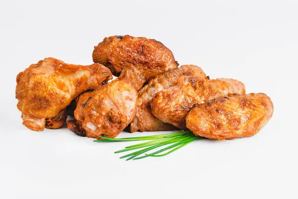 Chicken wings fried until half cooked, semi-finished product with fresh herbs on a white background. Fast food. Fast cooking.Quick cooking at home. Copy space.Fast homemade food.Raw chicken meat.