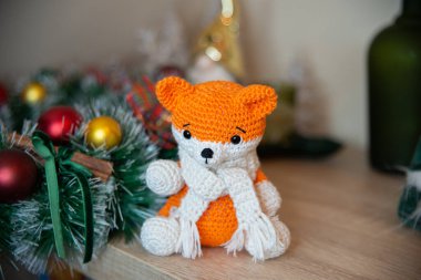 Crochet small handmade fox with a scarf in winter with Christmas decorations