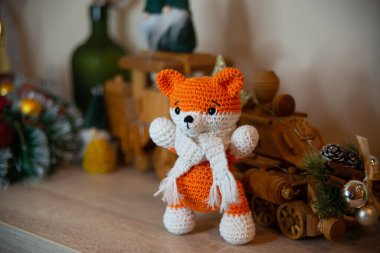Crochet small handmade fox with a scarf in winter with Christmas decorations