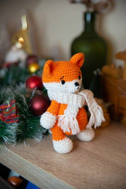 Crochet small handmade fox with a scarf in winter with Christmas decorations