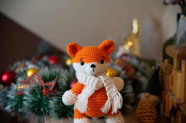 Crochet small handmade fox with a scarf in winter with Christmas decorations