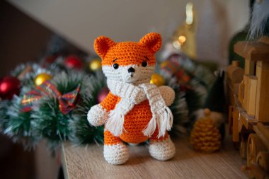Crochet small handmade fox with a scarf in winter with Christmas decorations