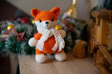 Crochet small handmade fox with a scarf in winter with Christmas decorations