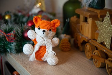 Crochet small handmade fox with a scarf in winter with Christmas decorations