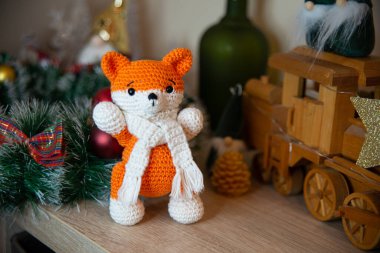 Crochet small handmade fox with a scarf in winter with Christmas decorations