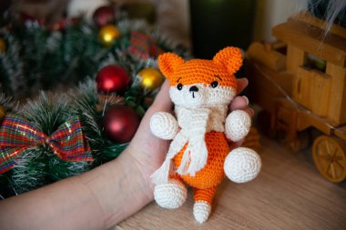 Crochet small handmade fox with a scarf in winter with Christmas decorations