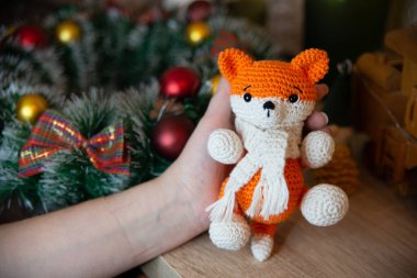 Crochet small handmade fox with a scarf in winter with Christmas decorations