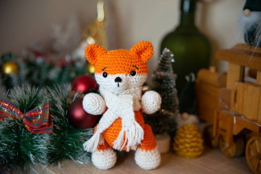 Crochet small handmade fox with a scarf in winter with Christmas decorations