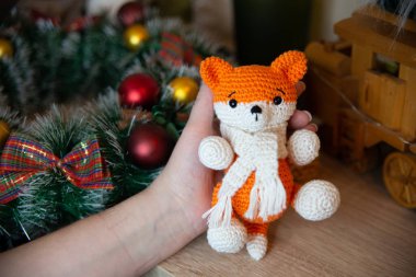 Crochet small handmade fox with a scarf in winter with Christmas decorations