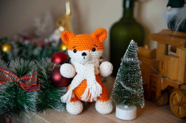 Crochet small handmade fox with a scarf in winter with Christmas decorations