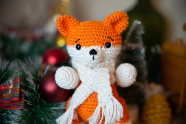 Crochet small handmade fox with a scarf in winter with Christmas decorations
