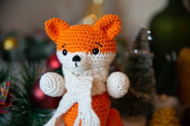 Crochet small handmade fox with a scarf in winter with Christmas decorations