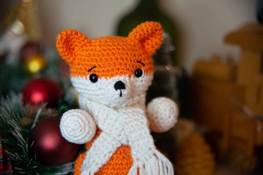Crochet small handmade fox with a scarf in winter with Christmas decorations
