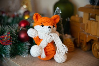Crochet small handmade fox with a scarf in winter with Christmas decorations
