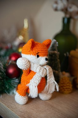 Crochet small handmade fox with a scarf in winter with Christmas decorations