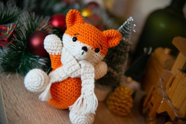 Crochet small handmade fox with a scarf in winter with Christmas decorations