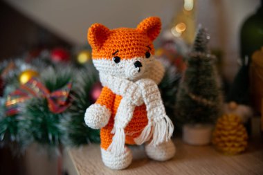Crochet small handmade fox with a scarf in winter with Christmas decorations
