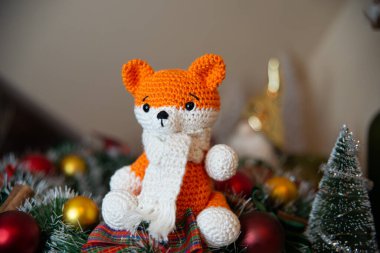 Crochet small handmade fox with a scarf in winter with Christmas decorations