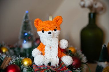Crochet small handmade fox with a scarf in winter with Christmas decorations