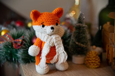 Crochet small handmade fox with a scarf in winter with Christmas decorations