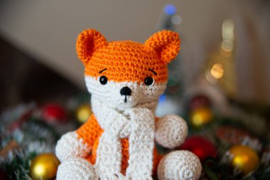 Crochet small handmade fox with a scarf in winter with Christmas decorations
