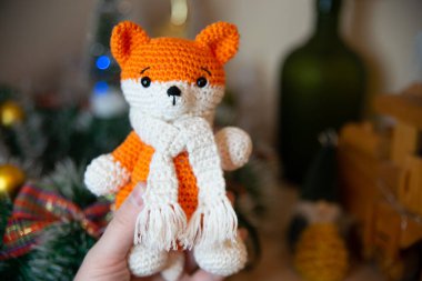 Crochet small handmade fox with a scarf in winter with Christmas decorations